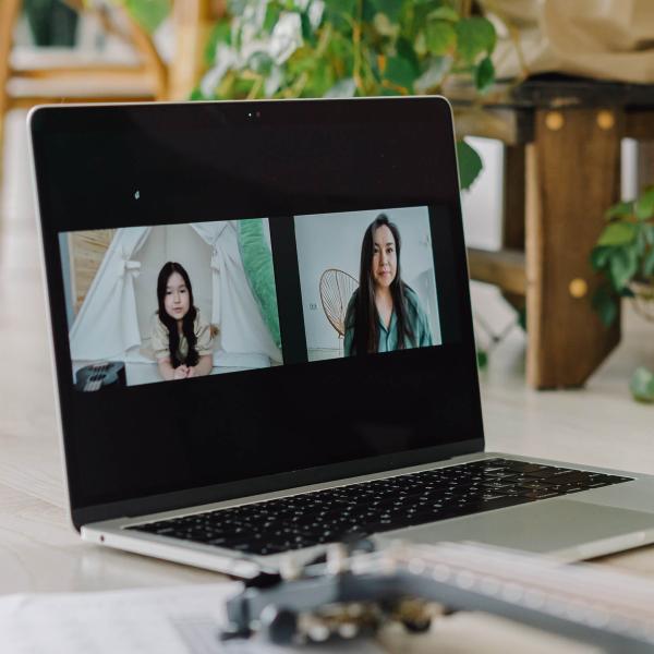 A laptop on a table showing two people in a video chat