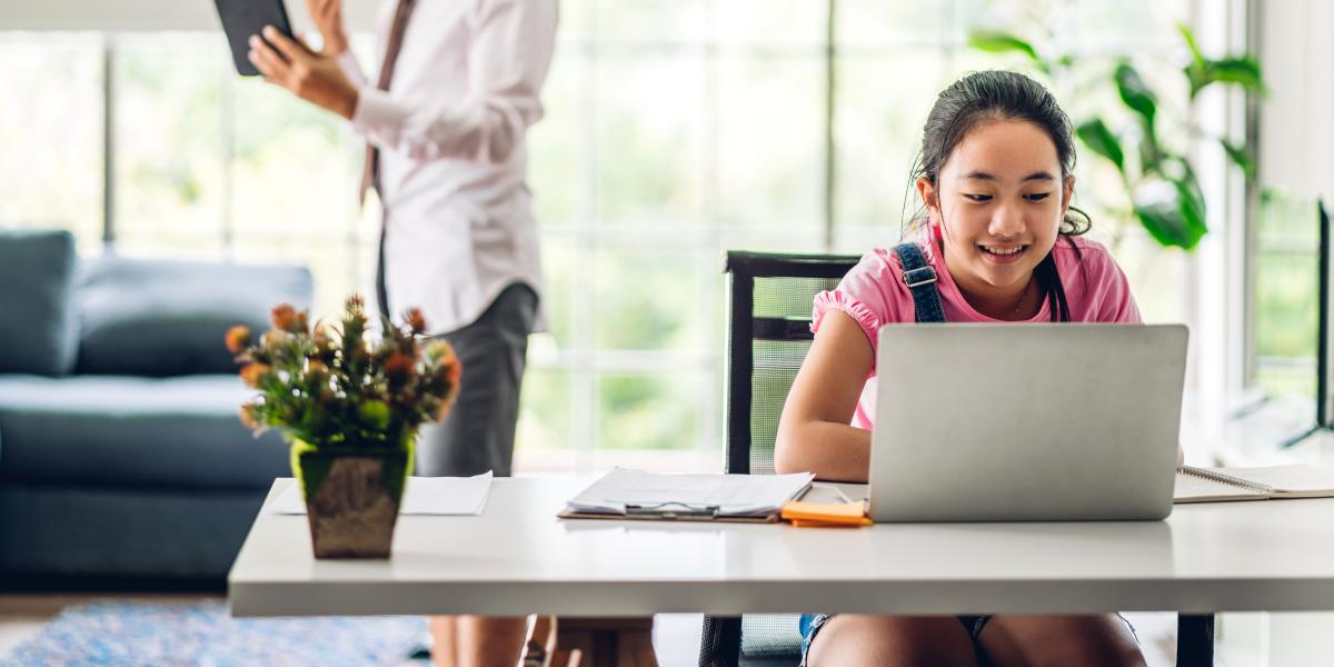 elementary age child working at home on her laptop